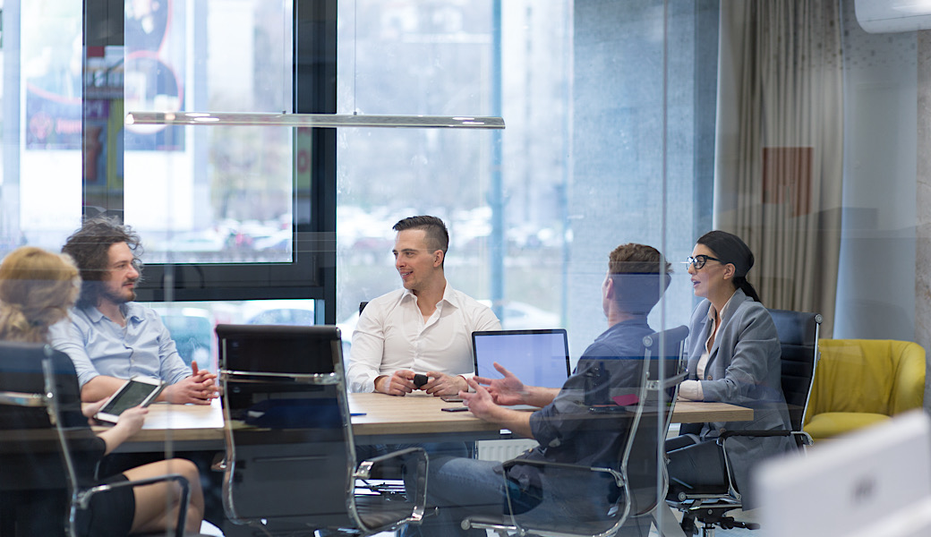 Group of a young business people discussing business plan at modern startup office building